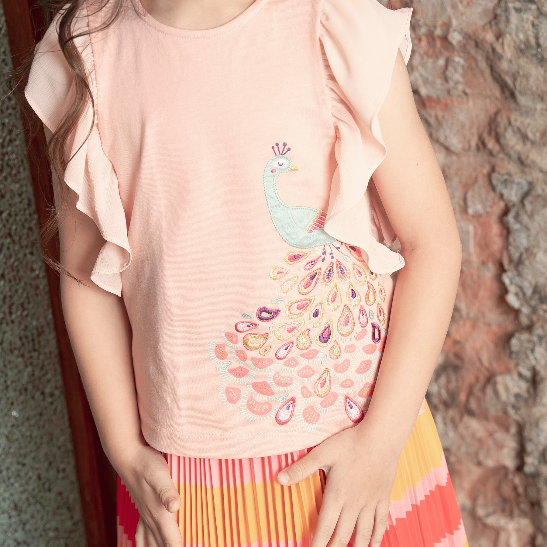 <tc>Light coral kids top with ruffle sleeves and peacock appliqué</tc>