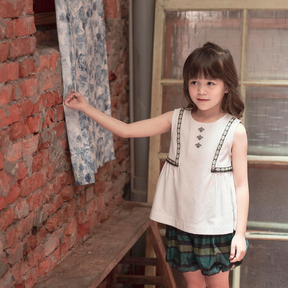 <tc>Ivory kids sleeveless top with tassels</tc>